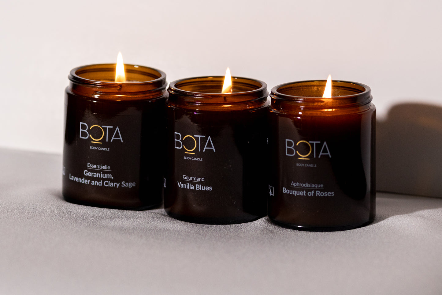 picture of bouquet of roses, Geranium, lavender and clary sage and vanilla blues body candle. All candles are lit